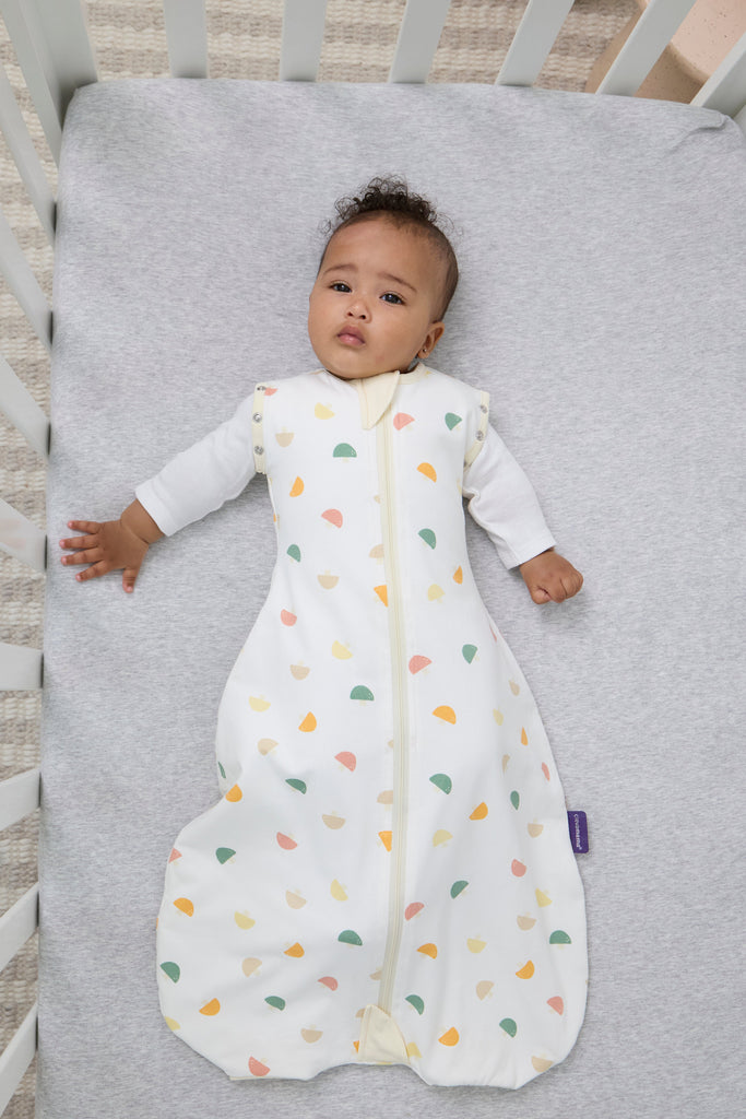 Baby lying on a crib mattress wearing a mushroom clevasleep dreamsuit