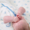 Close-up of a baby and their arms wearing a  blue dot clevasleep dreamsuit 